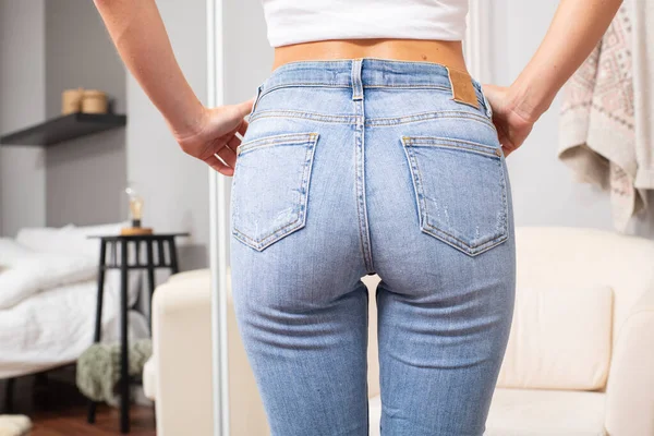 Woman wearing of jeans pants from back.