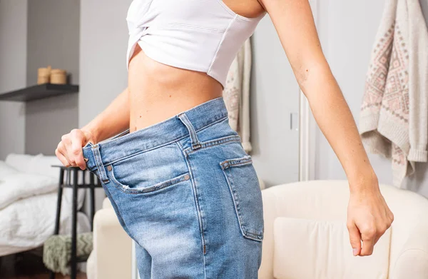 Slim girl in oversized jeans after successful diet. — Stock Photo, Image