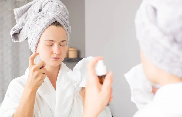 Skin care. Beautiful woman is spraying micellar water on face. — Stock Photo, Image