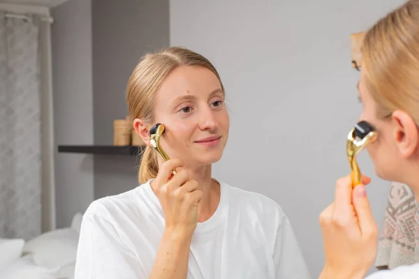 Dermaroller. Vrouw maakt procedure op gezicht met meso roller in huis — Stockfoto