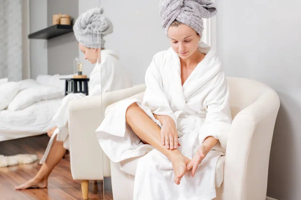 Woman is applying lotion on feet and doing foot massage — Stock Photo, Image