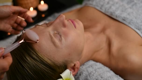 Cosmetologue Faisant Massage Professionnel Visage Aide Rouleau Jade Femme Recevant — Video