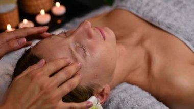 Kozmetik uzmanı parmaklarına masaj yaptırıyor, güzellik tedavi görüyor ve güzellik merkezinde yüz masajı yaptırıyor..