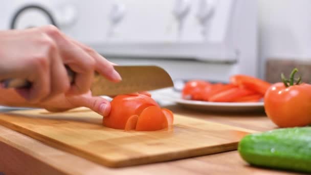 女性的手切割西红柿 女人用菜刀在木板上切新鲜的西红柿 — 图库视频影像