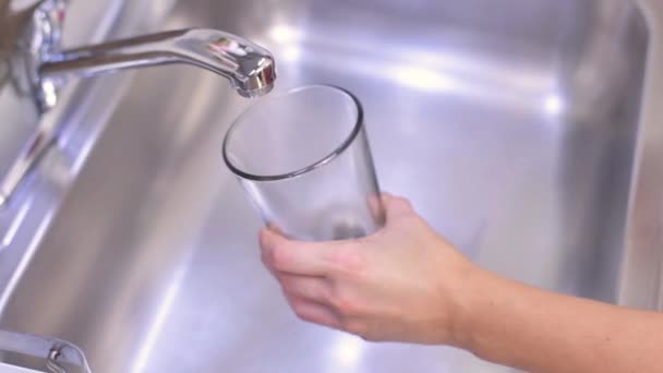 女性の手を開く蛇口と台所のガラスに飲料水を注ぐ — ストック動画