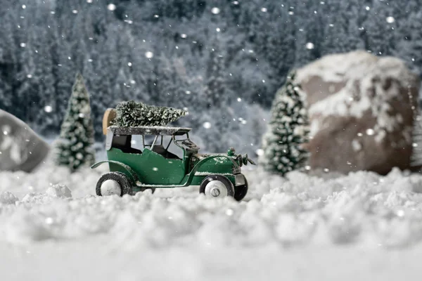 Miniatur-Oldtimer mit Weihnachtsbaum in verschneiter Winterlandschaft — Stockfoto