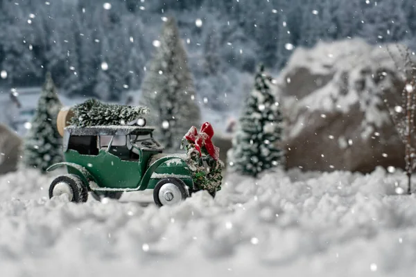 Miniature classic car carrying a christmas tree on snowy winter landscape — Stock Photo, Image