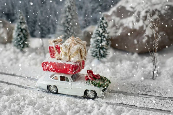 Miniatur-Oldtimer mit Weihnachtsgeschenken in verschneiter Winterlandschaft — Stockfoto