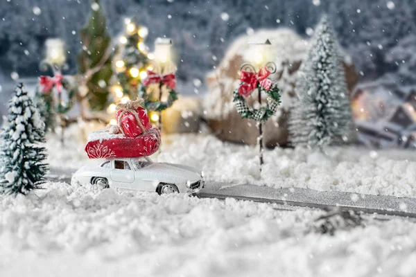 Miniatur-Oldtimer mit Weihnachtsgeschenken in verschneiter Winterlandschaft — Stockfoto