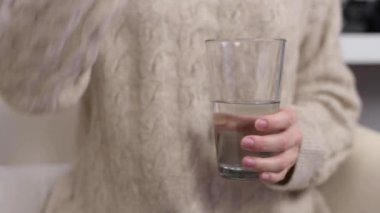 Kadın hapları, vitaminleri ya da hapları suyla alıyor.