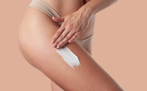 Cuidado corporal. Mujer aplicando crema contra la celulitis en las piernas . —  Fotos de Stock