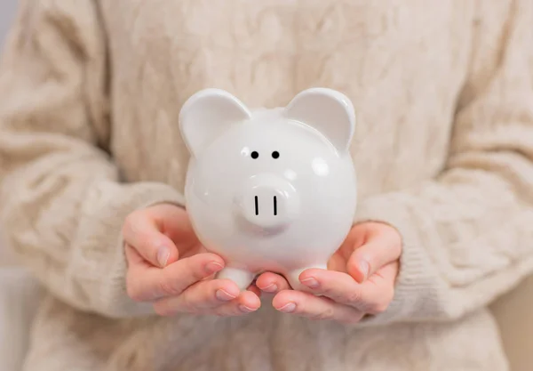 Woman is holding piggy bank in her hands — Stock Photo, Image