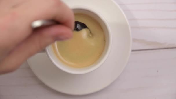 Vue du dessus de la main en remuant le café avec une cuillère. Coupe de café noir chaud à la maison .