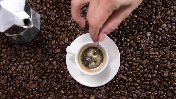スプーンでコーヒーを攪拌手のトップビュー ホットブラックコーヒーの家作りのカップ — ストック動画