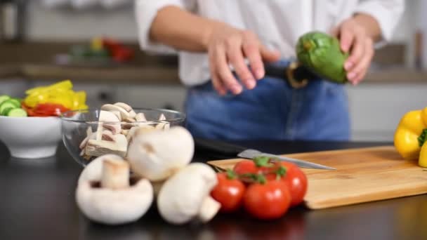 女性はスローモーションでキッチンのまな板にトマトを切っています サラダ用の新鮮な野菜 — ストック動画