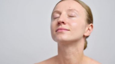 Cilt bakımı. Güzel bir kadın mahzen suyunu yüzüne püskürtüyor..