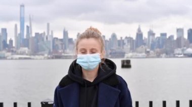 Coronavirus. Kadın, New York arka planında virüs salgını ve grip koruma maskesi takıyor.