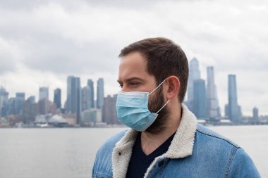 Adam tıbbi koruyucu maske takıyor. Koronavirüs salgını, bulaşıcı hastalıklar ve şehirdeki hava kirliliği sırasında sağlığın korunması