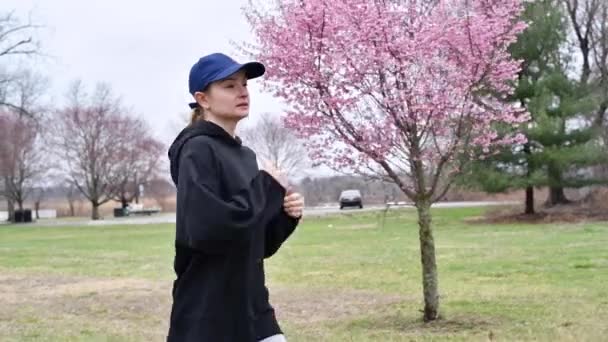 女性は公園で走っている 春の自然の中で外の若いランナーの訓練 — ストック動画