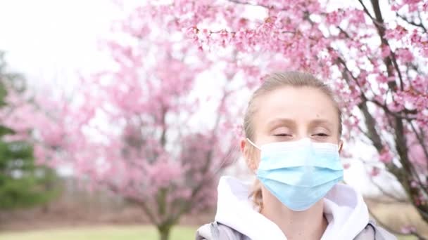 Schöne Frau Zieht Medizinische Maske Und Genießt Blühenden Baum Nach — Stockvideo