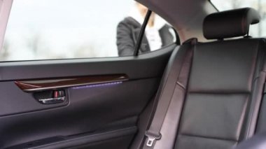 Yolcu vagonun kapısını açıyor ve taksiye biniyor. Kadın arabanın arka koltuğunda oturuyor.