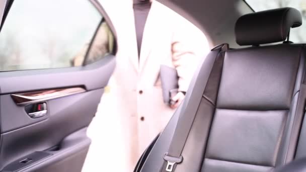 漂亮的年轻女子打开车门 坐上出租车 用智能手机发短信 — 图库视频影像