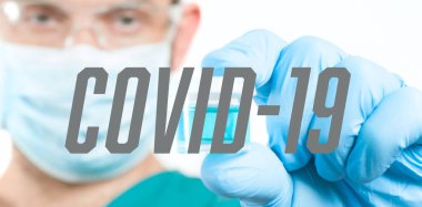Koruyucu gözlüklü doktor laboratuvardaki bilimsel örneğe bakıyor. Coronavirus aşısını araştırıyor. COVID-19.