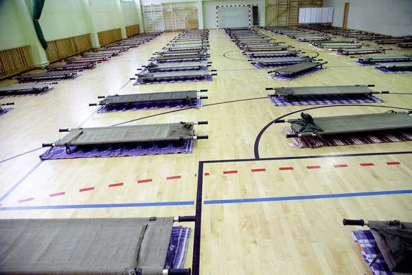 Spor salonundaki mülteci kampı sedyelerle dolu. 
