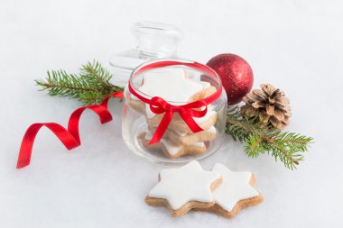 Noel ev yapımı yıldız kurabiye ile tam bir cam kavanoz kabarık beyaz arka plan üzerinde yakın çekim. Noel dekorasyon.