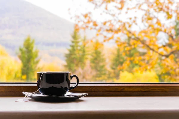 Eine Tasse Tee vor einem Fenster mit Herbstblick. — Stockfoto