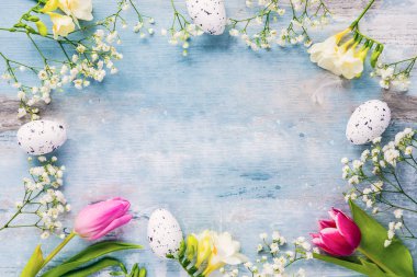 Paskalya arka plan. Bir çerçeve bahar çiçekleri ve Paskalya yumurtası. Kopya alanı.
