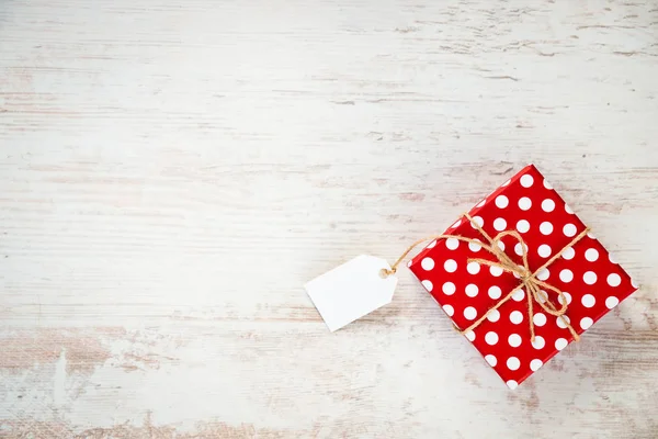 Felülnézete a piros pöttyös ajándék doboz alatt fehér fa háttér. Másolja a hely. Üres Megjegyzés. — Stock Fotó