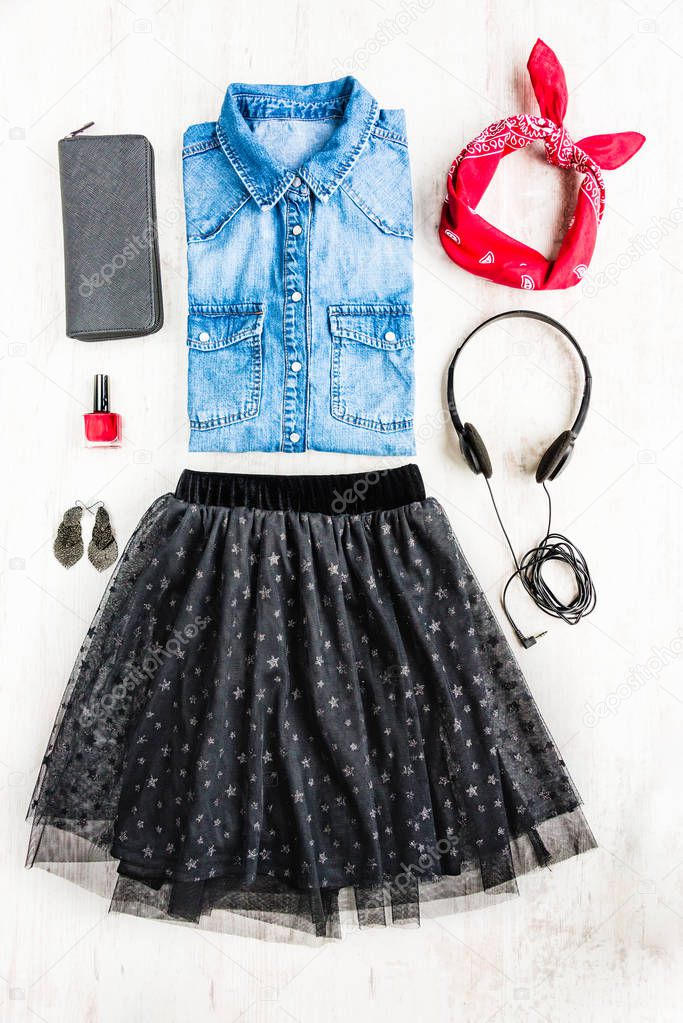 Top view of female clothes. A collage of woman tull skirt, denim shirt and accessories. Fashionable urban outfit.