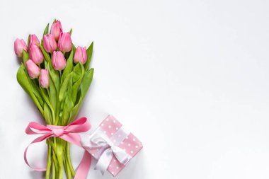 Üstten Görünüm Pembe Lale buketi, pembe kurdele ve pembe noktalı hediye kutusu ile beyaz arka plan üzerinde sarılı. Kopya alanı.