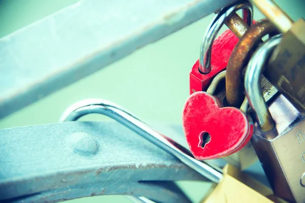 Feche o cadeado de amor em forma de coração trancado no trilho de uma ponte - um símbolo e uma promessa de amor eterno — Fotografia de Stock