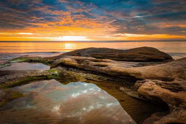 Malowniczy wschód słońca nad skalistą plażą. — Zdjęcie stockowe