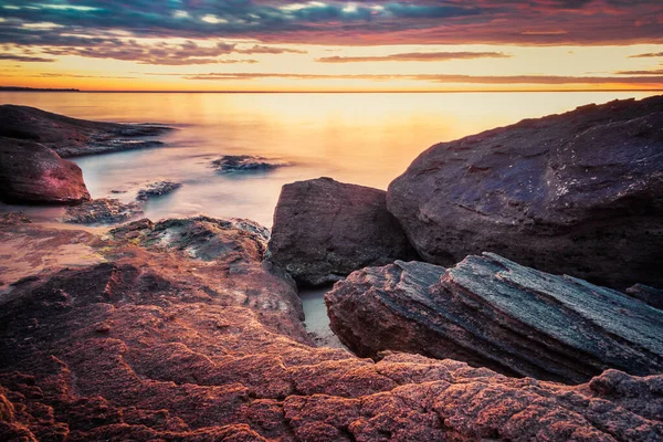 Живописный восход солнца над скалистым пляжем . — стоковое фото