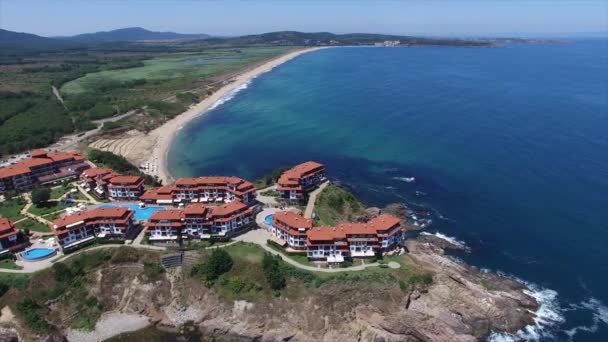 Vue aérienne d'un complexe de luxe sur une petite péninsule de la mer Noire avec une longue plage de sable — Video