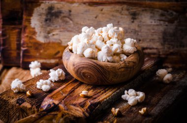 Ahşap kase rustik masada ahşap vintage kapta tatlı patlamış mısır dolu. Vintage tarzı. Seçici odak