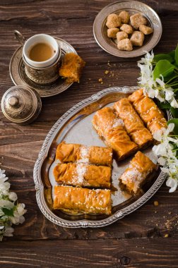 Ev yapımı baklava rulo olarak demir ahşap arka plan üzerinde deneyin. Ramazan yemek. Seçici odak