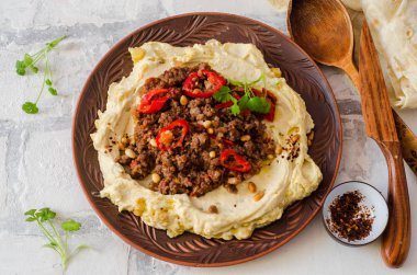 Kremsi Humus ile baharatlı koyun eti et kil kase taş zemin üzerine kıyılmış. Ramazan yemek. Üstten Görünüm