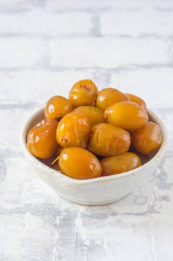 Tuğla duvar arka plan üzerinde bir kapta çiğ taze tarihleri kapatın. Seçici odak.