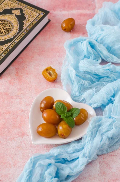 Date fresche crude e menta verde in una ciotola vicino al Corano su sfondo di pietra. Concentrazione selettiva. Cibo del Ramadan. Vista dall'alto — Foto Stock