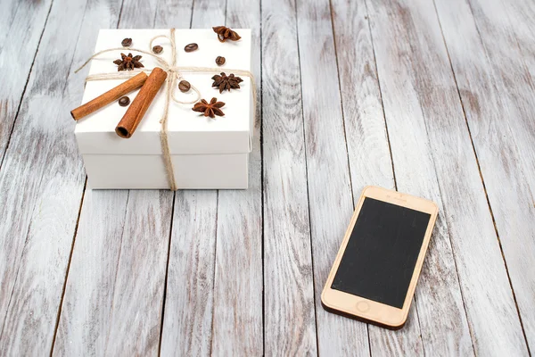 Caja de Navidad decorada con canela, anís, café, frijoles y teléfono sobre fondo de madera.Concepto de vacaciones de invierno. Espacio para texto . — Foto de Stock