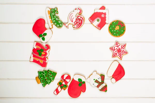 Biscoitos de gengibre coloridos de Natal em fundo de madeira branca. Conceito de férias de inverno. Espaço para texto . — Fotografia de Stock