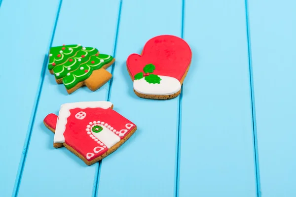 Biscoitos de gengibre coloridos de Natal em fundo de madeira azul. Conceito de férias de inverno. Espaço para texto . — Fotografia de Stock