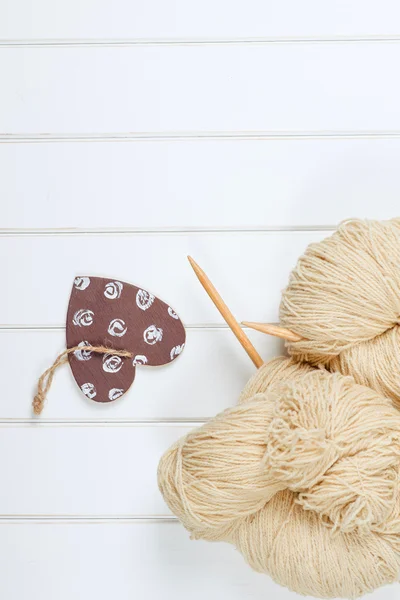 Hilados de lana natural con agujas de madera sobre fondo de madera blanco . — Foto de Stock