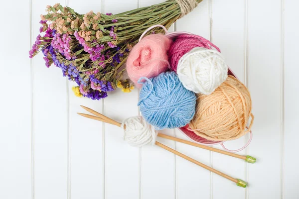 Knitting yarn balls and needles on white wooden background. — Stock Photo, Image