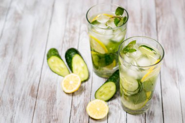 Limon, nane ve salatalığın üzerinde ahşap açık renkli su. Suyu Detoks.