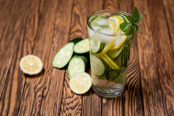 Water met citroen, munt en komkommer op houten achtergrond. Water Detox. — Stockfoto